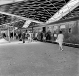 856400 Afbeelding van in- en uitstappende treinreizigers op het eerste perron van het nieuwe N.S.-station Tilburg te Tilburg.
